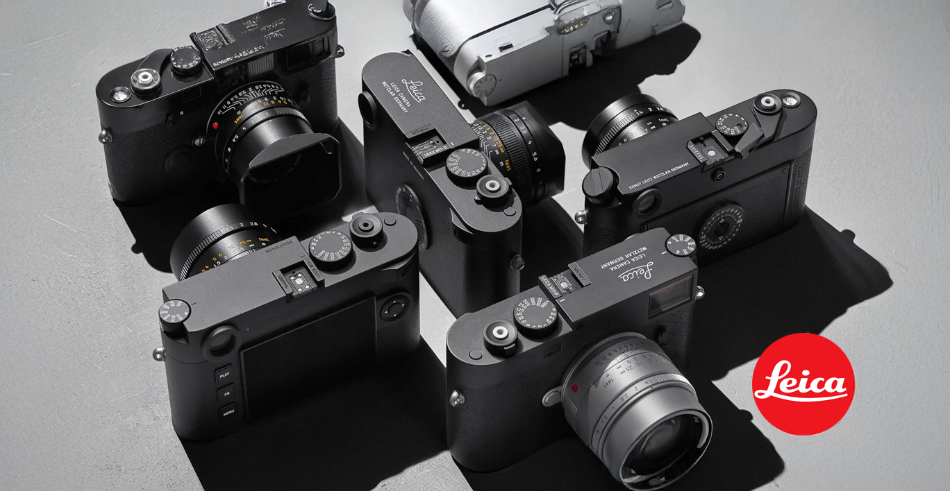 Mehrere schwarze Leica Kameras mit Objektiven in Draufsicht arrangiert, daneben das rote Leica Logo.“  Möchtest du, dass ich den Alt-Text stärker SEO-orientiert formuliere (z. B. mit Keywords wie „Leica Kameras
