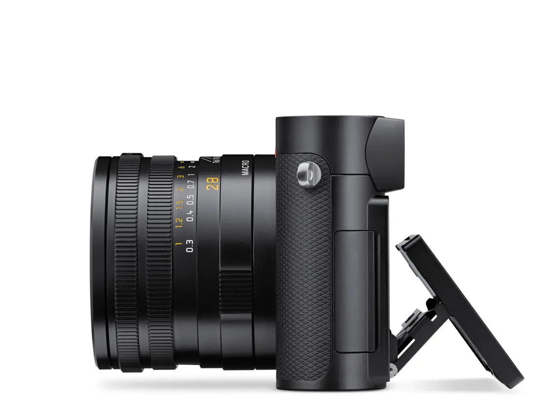 Schwarze Leica Q3 in seitlicher Ansicht mit fest verbautem 28-mm-Objektiv, Makro-Einstellung und ausgeklapptem Display vor weißem Hintergrund.