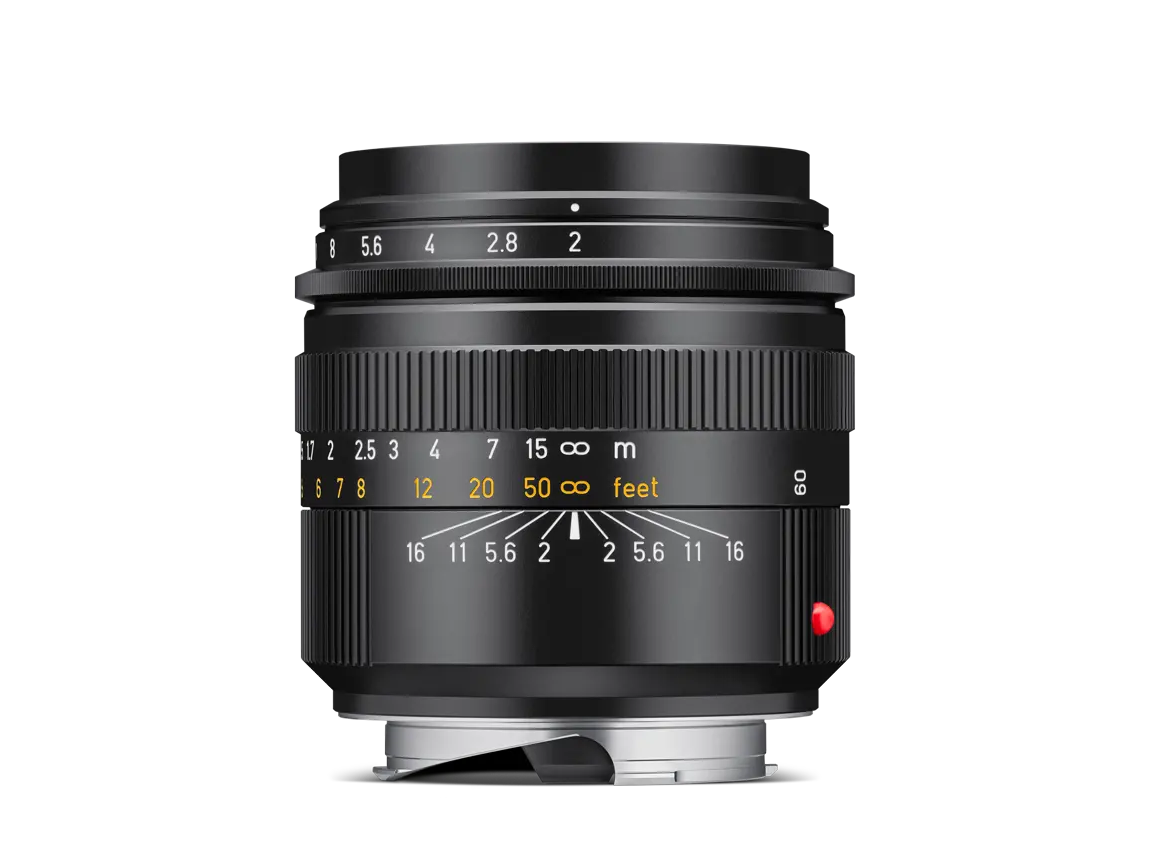 Schwarzes Leica 50-mm-Objektiv mit Lichtstärke f/2, Entfernungsskala und rotem Leica-Punkt in seitlicher Ansicht vor schwarzem Hintergrund.